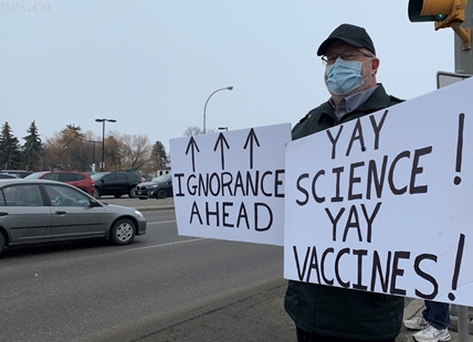 Kelowna man well known for counter-protesting pandemic measures hangs up his signs