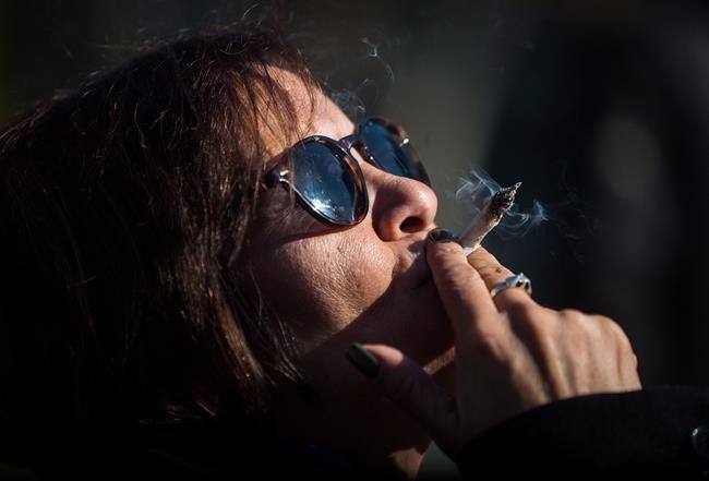 Anne Genovy smokes marijuana while celebrating the legalization of recreational cannabis in Vancouver, on Wednesday Oct. 17, 2018. A new survey has found one in four Canadian adults have reported using cannabis at least once in the past 12 months. THE CANADIAN PRESS/Darryl Dyck