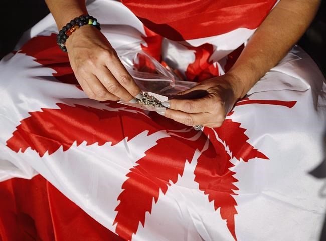 A cannabis user rolls a joint at a rally outside government's offices following the legalization of cannabis in Calgary, Alta., Wednesday, Oct. 17, 2018.A Quebec Superior Court Judge is hearing the final day of arguments in a legal challenge by a Montreal-area head shop to a provincial law that bans the sale of products that reference cannabis.THE CANADIAN PRESS/Jeff McIntosh