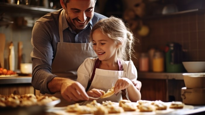 Smiling father and daughter baking in a kitchen