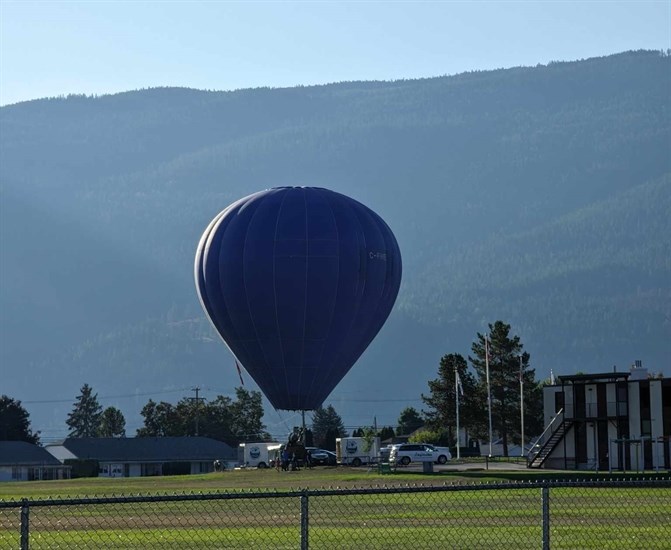 Blue air balloon lifts off from a middle school field, Armstrong. 