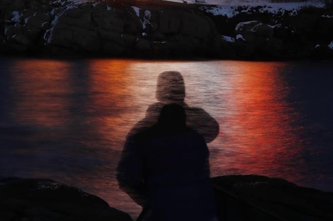 FILE - In this photo made with a long exposure, a man is silhouetted against lights reflected in the waters off Cape Neddick in Maine on Dec. 11, 2017. A study published Thursday, Sept. 14, 2023, in the journal Nature Medicine has found that the psychedelic drug MDMA, combined with talk therapy, can reduce symptoms of post-traumatic stress disorder.