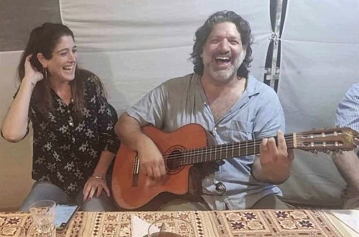This image provided by Eran Shani shows Shlomi Mathias playing the guitar as his wife, Debbie ‘Shahar’ Mathias, laughs and sings next to him at her 50th birthday party on Oct. 1, 2023, in Lehavim, Israel. They both died days later while protecting their 16-year-old son, Rotem Mathias, from Hamas fighters who attacked their kibbutz in Israel near the border with Gaza on Oct. 7, 2023. 