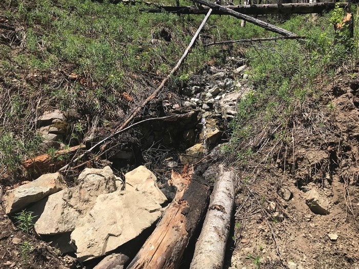 BCWF uncovered a redirected stream with no culvert packed with rocks and logs.