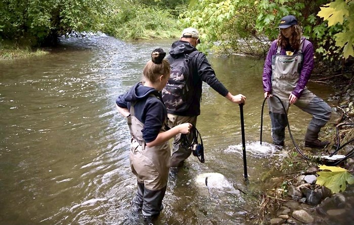Jane Pendray of the Pacific Salmon Foundation tests out an aerator system with members of the Tsolum River Restoration Society.