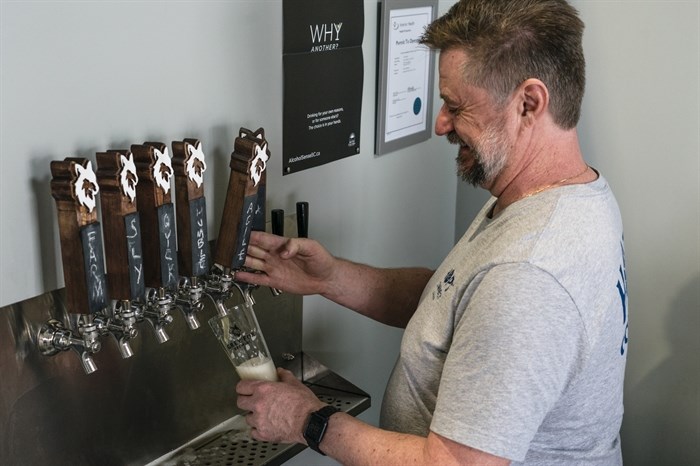 Chris Neufeld, owner and brewmaster at Grey Fox, pouring a pint of his gluten-free beer.