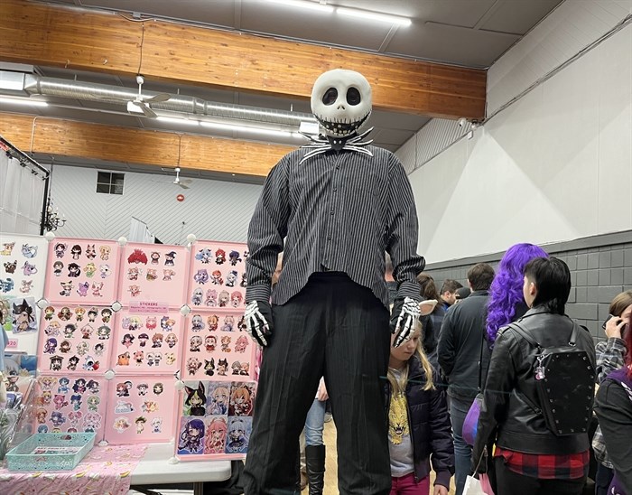 A cosplayer on stilts to be a towering Jack Skellington from 