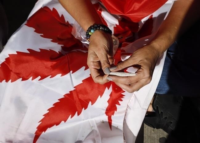 Albertans will soon see pot shops selling cannabis at some festivals and trade shows. The province says it will begin allowing licensed cannabis retailers to operate temporary sales locations at adults-only events come Jan. 31. A cannabis user rolls a joint at a rally in Calgary, Alta., Wednesday, Oct. 17, 2018.
