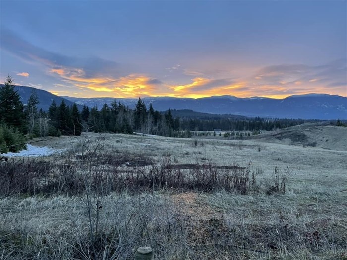 A sunset peeks out of clouds over a frosty field near the south Canoe trails in Salmon Arm. 
