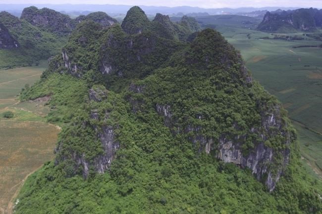 This photo provided by researchers shows a mountain where fossils of Gigantopithcus blacki were found in caves in the Guangxi region of southern China.