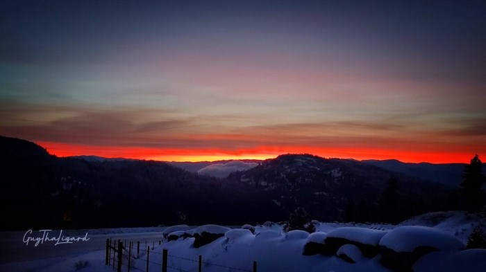 A gold, fiery sunset is seen over the hills in Penticton. 