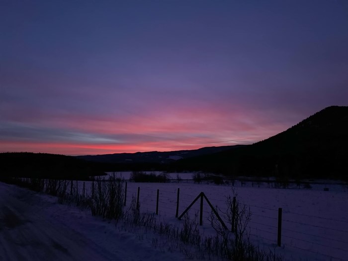 Pinks and purples are seen in this sunset over a snowy field and mountains in Kamloops. 