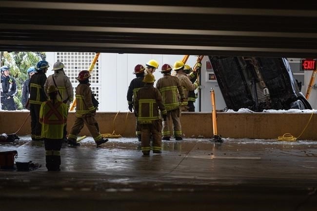 Vancouver Fire and Rescue Services attend to a parkade at the University of British Columbia Campus, where a car plunged through a concrete wall from the second storey of a parking lot on Wednesday, Jan. 17, 2024.