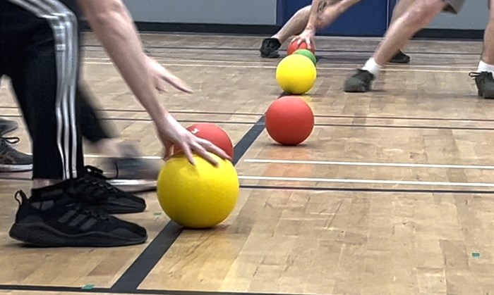 Players scrambling for a ball to start off a game of dodgeball at Urban Rec's dodgeball league on Jan. 16, 2024. 