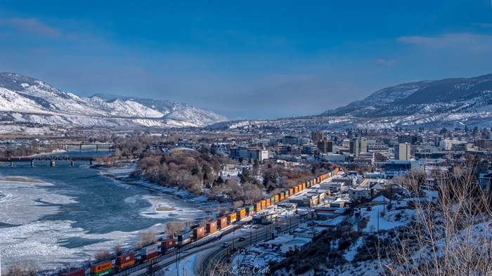 A frosty, sunny day in Kamloops showing a train and icing over Thompson River. 