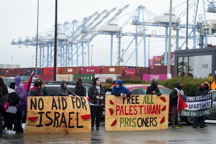 FILE - Protesters against the Israel-Hamas war hold up large wooden signs as they block the main Port of Tacoma entrance to delay the loading of the Cape Orlando vessel, Monday, Nov. 6, 2023, in Tacoma, Wash.