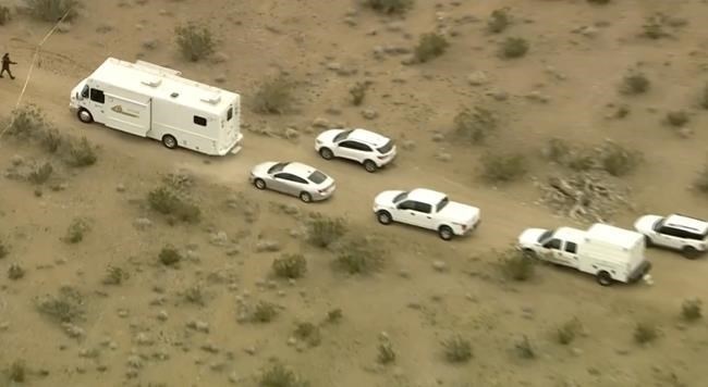 FILE - This aerial still image from video provided by KTLA shows law enforcement vehicles where several people were found shot to death in El Mirage, Calif., Wednesday, Jan. 24, 2024. The San Bernardino County Sheriff's Department said Monday, Jan. 29, that arrests have been made in the investigation into six bodies found dead at a dirt crossroads in the Southern California desert last week. 