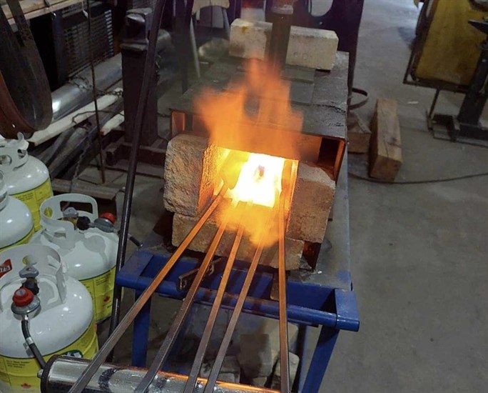 Some chunks of metal heating up in a forge before becoming something useful.