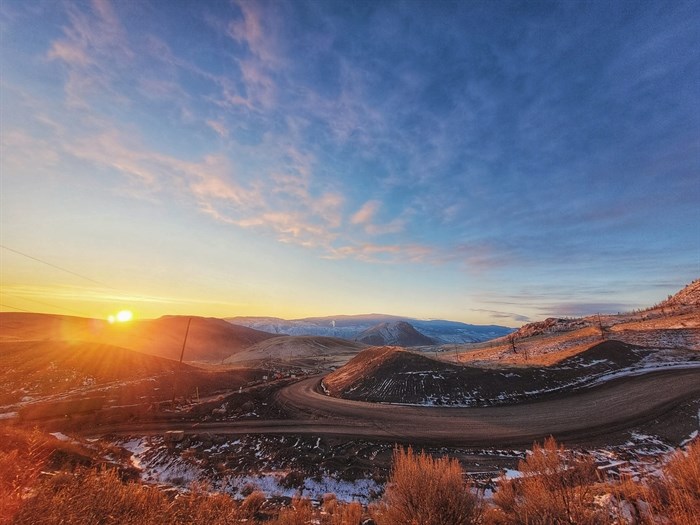 The sun is seen glowing over the mountain in Cache Creek. 