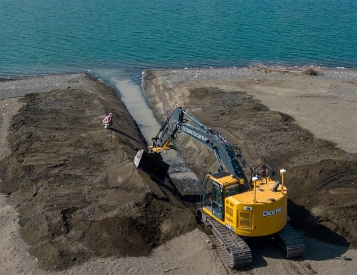 An excavator is seen opening an access channel for pink salmon to leave Kamloops Lake and access spawning grounds up Tranquille Creek. 