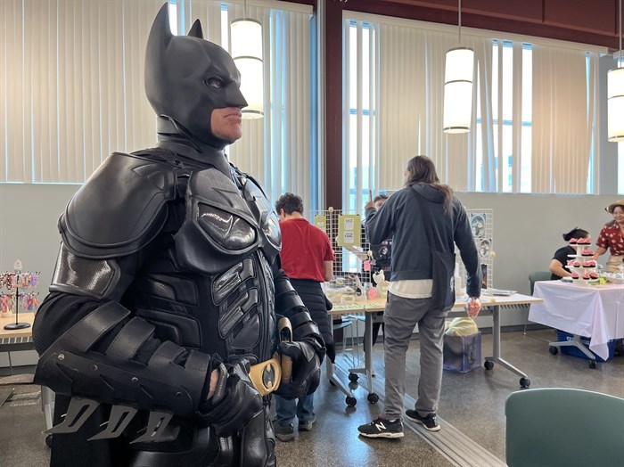 A cosplayer posing as Batman for people to sit and draw him in the Okanagan Regional Library in downtown Kelowna.