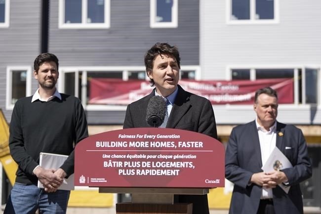 Prime Minister Justin Trudeau, centre, is flanked by Minister of Housing, Infrastructure and Communities Sean Fraser, left, and mayor of Halifax Mike Savage while making a housing announcement in Dartmouth, N.S. on Tuesday, April 2, 2024.
