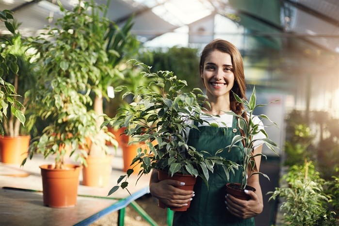 Happy gardener holding plants
