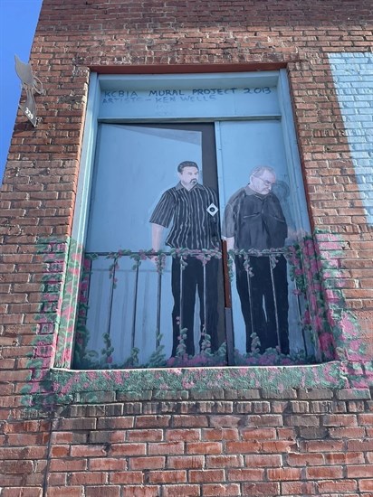 People appear to look down at the street in this mural found in Kamloops. 