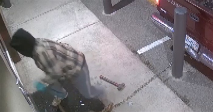 An image of one of the suspects breaking into the front of Skye Cannabis. 