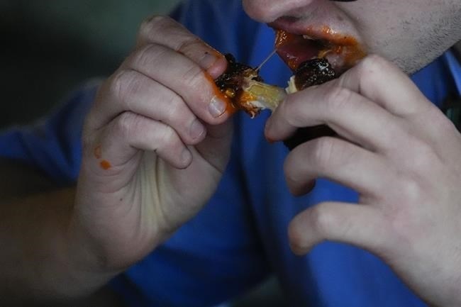 A man eats a chicken wing, Wednesday, June 12, 2024, at a barbecue restaurant in Cincinnati. Psychologists have known for years now that men tend to eat more meat than women, but a study of people around the world now reveals that that's true across cultures. 