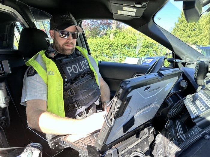 FILE PHOTO - A BC RCMP officer is seen working with a computer in a police vehicle in this undated image.