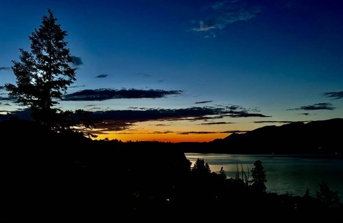 The sunset is orange over Okanagan Lake in Summerland. 