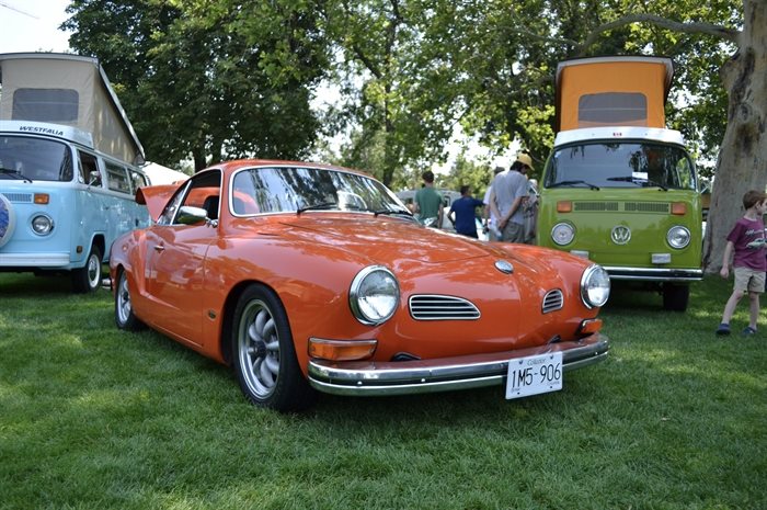 A Volkswagen Karmann Ghia and some modified VW buses in the background in Kelowna