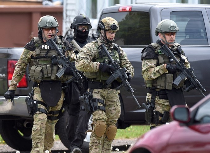 Emergency response officers check a residence in Moncton, N.B. on Thursday, June 5, 2014. Three RCMP officers were killed and two injured by a gunman wearing military camouflage and wielding two guns on Wednesday. Police have identified a suspect as 24-year-old Justin Bourque of Moncton.