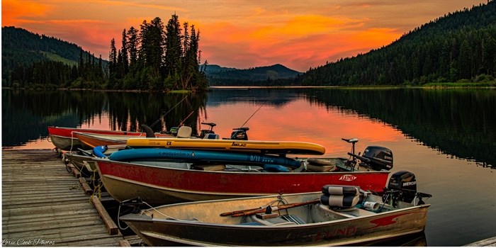 The sky is orange as the sun sets at a lake near Kamloops.