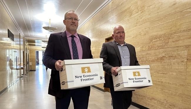 FILE - Steve Bakken, left, and Casey Neumann, of the New Economic Frontier ballot initiative group, carry boxes containing petitions to the Secretary of State's Office on Monday, July 8, 2024, at the state Capitol in Bismarck, N.D.