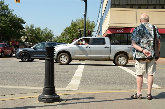 A pedestrian waits to cross at the intersection at 30 Ave and Highway 97 where 15-year-old Lynza Henke was killed.