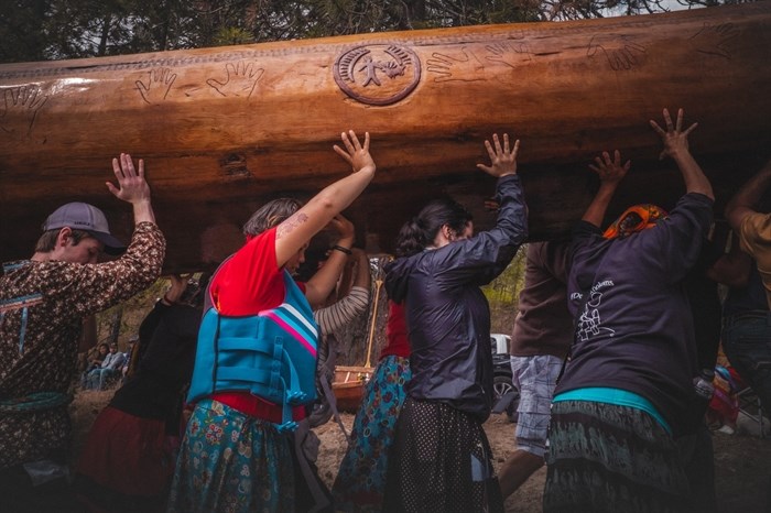 Sinixt people carry a dugout cedar canoe during a week-long canoe journey through their ancestral waterways in 2022, which saw Sinixt people living in the U.S. cross over the colonial border to reconnect with their territory in British Columbia.
