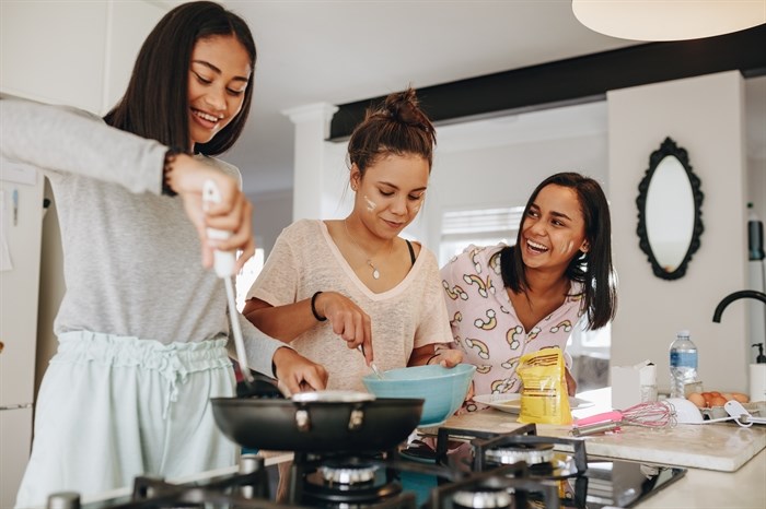 Three young adults standing in the kitchen