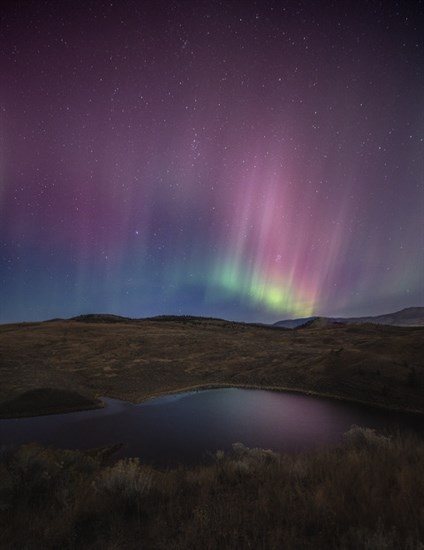 Northern lights shimmer over hills and water in the Kamloops area in October.  