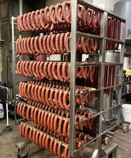 Racks of smoked sausages hang at Gary