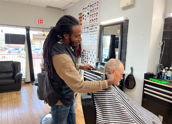 George White, a barber at Dre's Hair Salon in Kelowna, cutting a customer's hair.