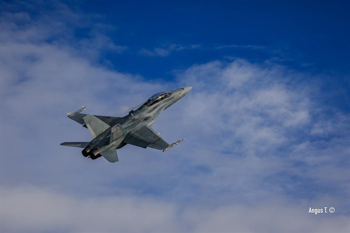 A Royal Canadian Air Force military jet flies through blue skies over Kamloops. 