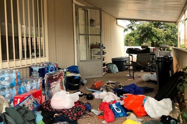 FILE - Cases of bottled water are seen with other items left on the porch of a house where killings occurred related to a Marijuana growing operation in Aguanga ,Calif., Tuesday, Sept. 8, 2020.