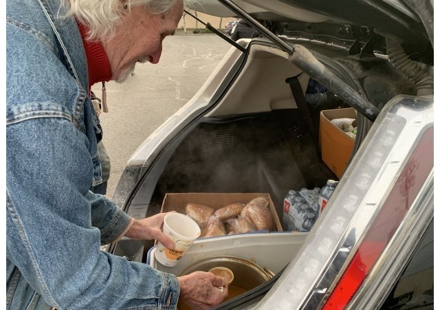 From the back of his Toyota Prius, Hilke serves soup, sandwiches, snacks and water at the Ministry of Social Development offices on Dec. 20, 2024.