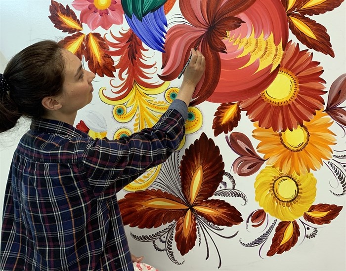 Stefania Miroshnichenko painting a mural.