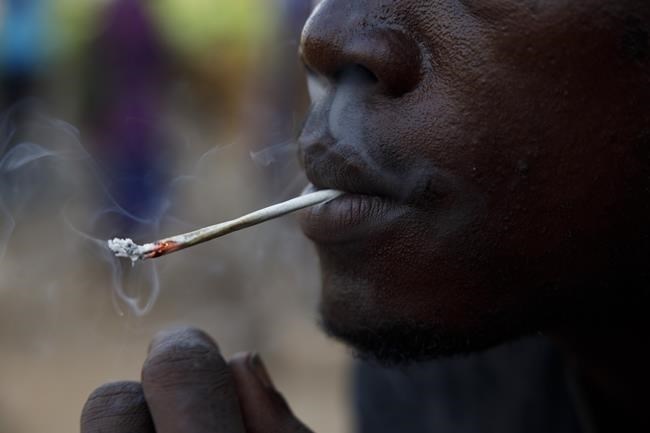 FILE - A young man smokes Kush, a derivative of cannabis mixed with synthetic drugs like fentanyl and tramadol and chemicals like formaldehyde, at a hideout in Freetown, Sierra Leone, April 29, 2024.
