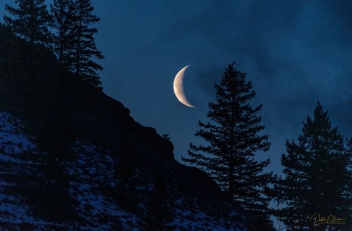 A crescent moon shines bright from Kamloops skies. 