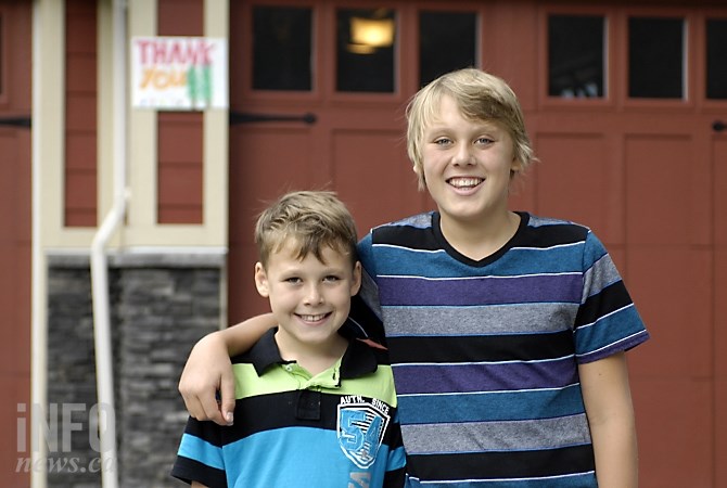 Noah Thiessen (13) and his brother Carter (10) were among those who put up thank you signs for fire crews who protected their homes during the Smith Creek fire.