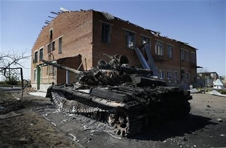 A burned Ukrainian army tank is seen near a destroyed kindergarten in the village of Kominternove, Ukraine, Saturday, Sept. 6, 2014.